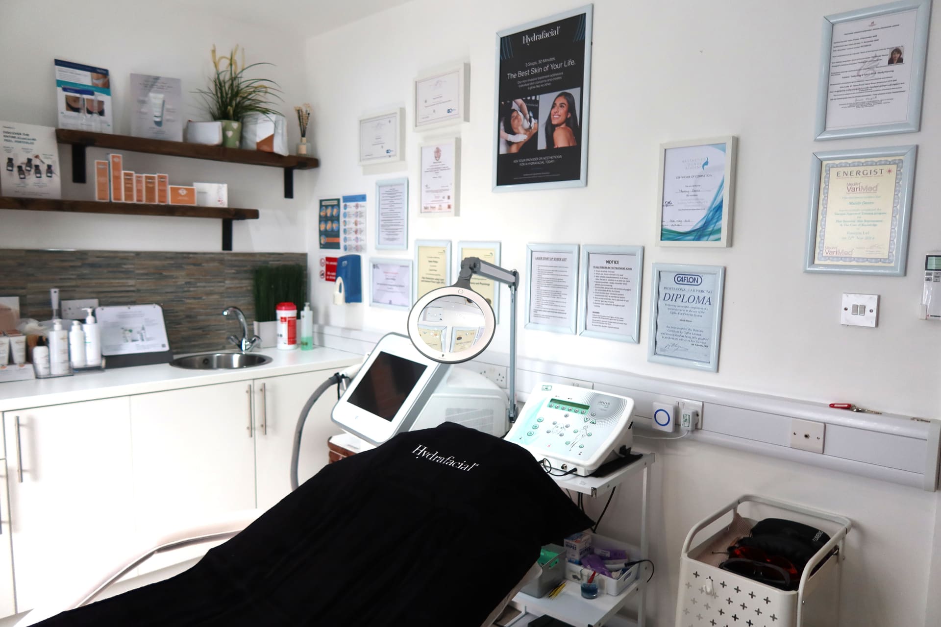 Treatment room with medical-grade devices and accreditations at Vale Laser Aesthetics Pontyclun